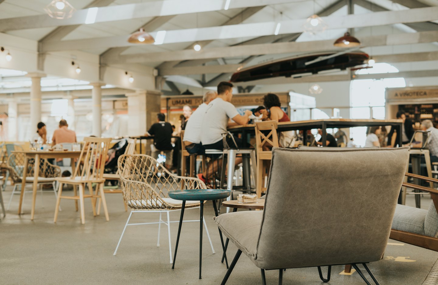 People dining and socializing in a modern indoor food hall.