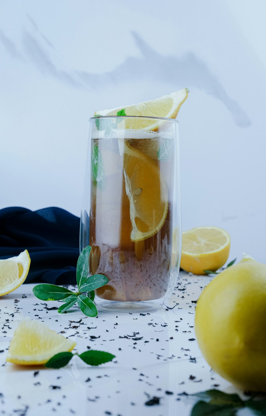 Glass of iced tea with lemon slices and mint leaves.